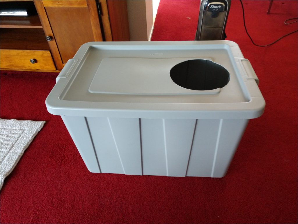 The finished homemade cat box a 30 gallon gray storage tub with a 9 inch hole cut in one end of the lid